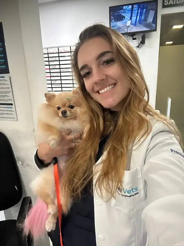Dentista Veterinária Mariana Neves segurando um cão lulu da pomerânia durante atendimento