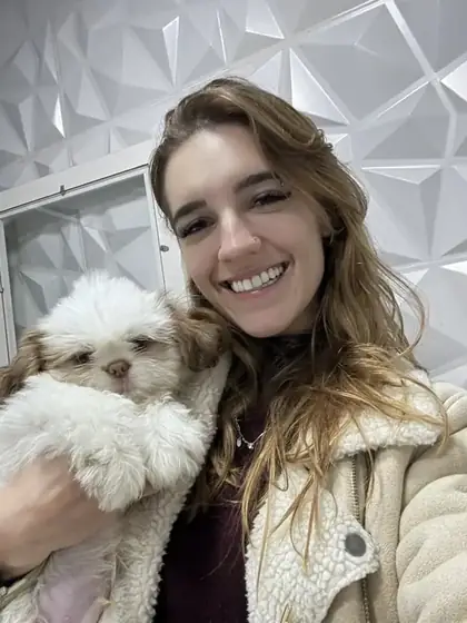 Dentista Veterinária Mariana Neves com um shih tzu no colo após a consulta